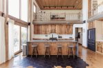Stunning kitchen with bar seating and glimpses of the lake through the trees